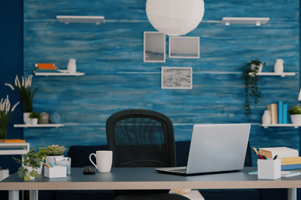 Blue home office with laptop and decorative shelves